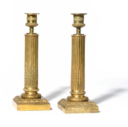 null Pair of gilt bronze torches, the columnar shaft with flutes and asparagus resting...