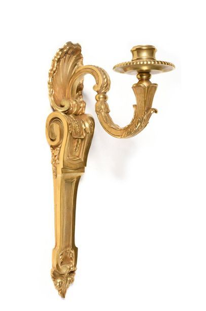 null A suite of four gilt bronze wall lights with a light arm, shell and scroll decoration....