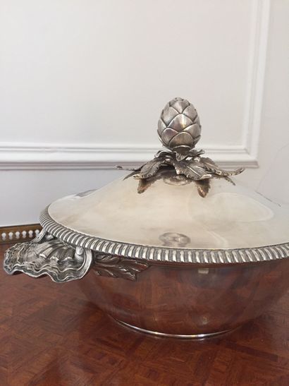 null Covered silver soupier with shell-shaped side grips. The lid has a beaded edge...