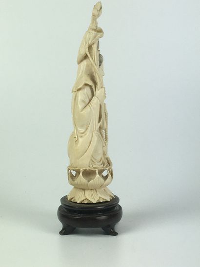  CHINE Statuette en ivoire à décor d'une divinité sur un lotus. Socle bois. Première...