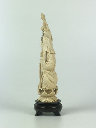  CHINE Statuette en ivoire à décor d'une divinité sur un lotus. Socle bois. Première...