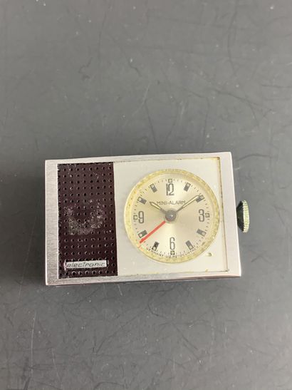 null MINI-ALARM Vers 1970. Petite montre réveil de voyage rectangulaire avec cadran...