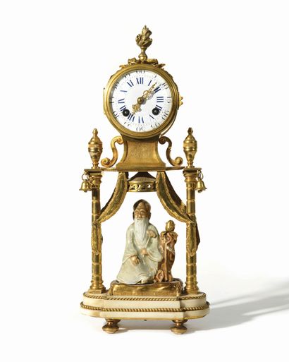 null An ormolu and white marble hanged clock with two uprights surmounted by vases...