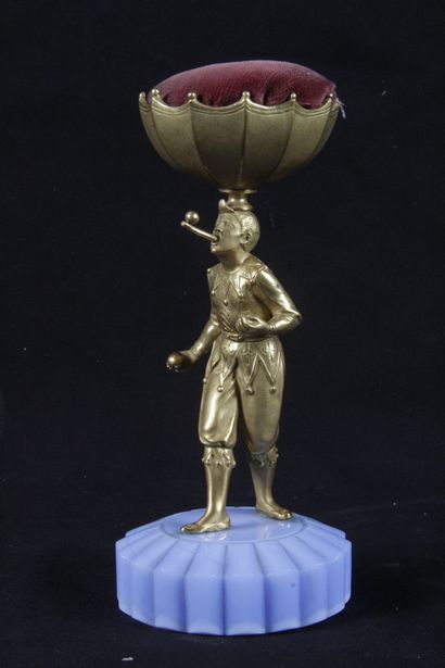 null GOLDEN BRONZE SPINGLE HOLDER, showing a juggler carrying a red velvet ball on...