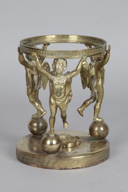 null A bronze CUP MOUNT with three cherubs perched on spheres and holding a ring....