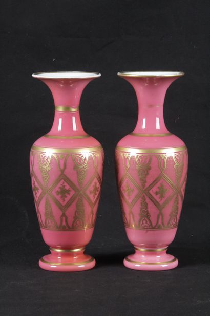 null A pair of pink opaline vases decorated with gilded borders and foliage in rhombuses....