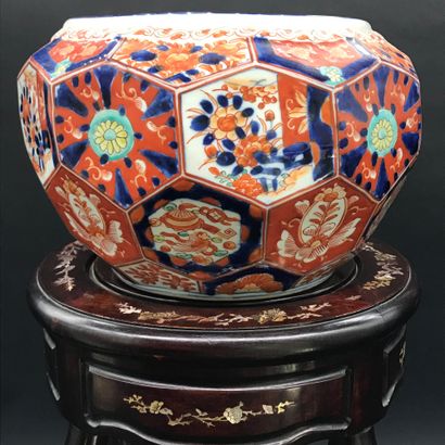 null IMARI 

A polychrome porcelain planter decorated with flowers on a carved wooden...