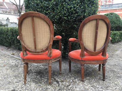  A pair of medallion-backed armchairs in natural wood, resting on four fluted tapered...