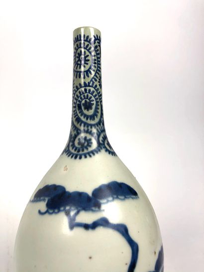 null JAPON Deux bouteilles à saké en porcelaine décorées en bleu d´un pin parasol...