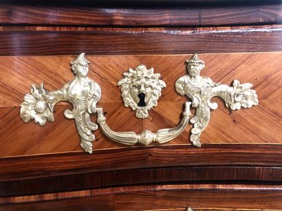 null A veneer and marquetry chest of drawers opening in front with four drawers on...