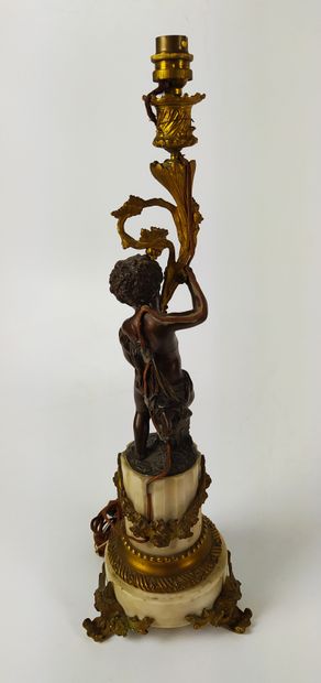  CANDELABRE monté en lampe à décor d'un angelot en bronze patiné sur une base en...