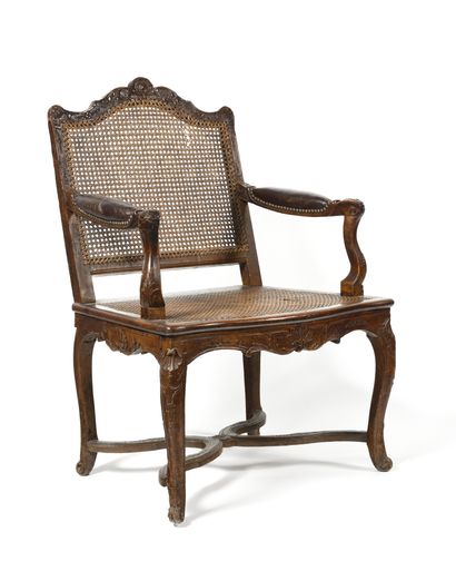 null Cane armchair with a flat back in moulded and carved natural wood, the armrests...