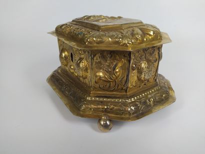 null A vermeil repoussé box with cut sides, resting on four ball feet. The lid depicts...