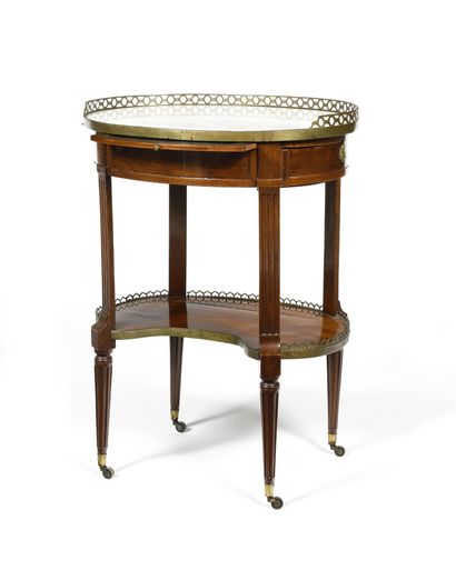 null A mahogany and mahogany veneer GUERIDON TABLE opening at the waist with a central...