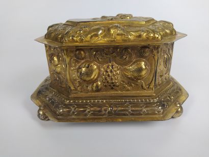 null A vermeil repoussé box with cut sides, resting on four ball feet. The lid depicts...