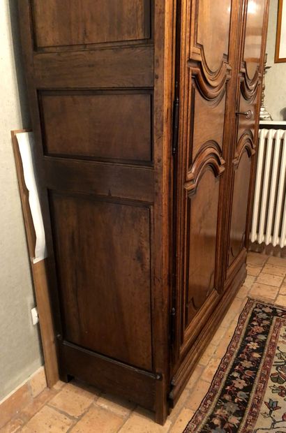 null A walnut and chestnut moulded cupboard opening with two doors in front with...