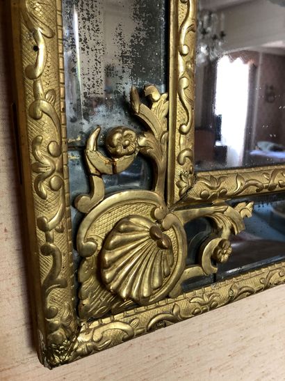 null A large mirror in gilded and carved wood, the pediment decorated with birds....