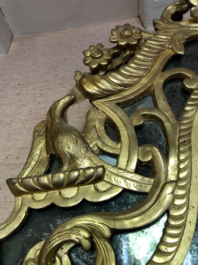 null A large mirror in gilded and carved wood, the pediment decorated with birds....