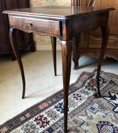 null WRITING TABLE in stained walnut opening with a drawer in the waist and resting...