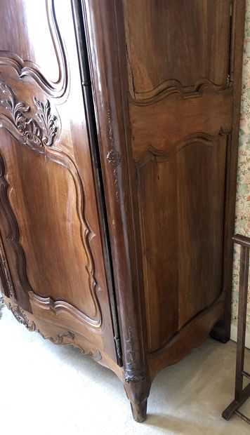 null WARDROBE in blond walnut very finely carved and moulded. Strongly curved front...