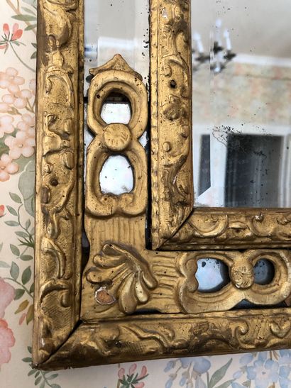 null A gilded wood mirror with moulded and carved lambrequins and decorated with...