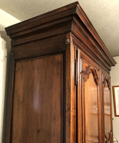 null A walnut and chestnut moulded cupboard opening with two doors in front with...