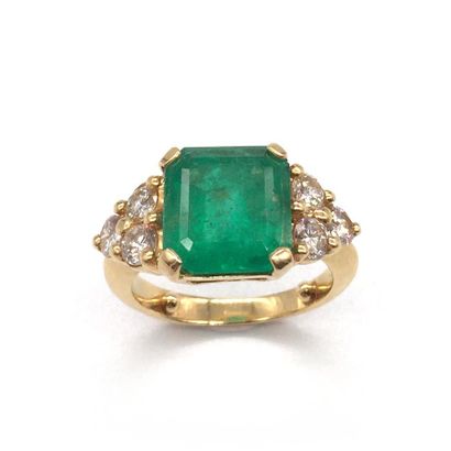 null RING presenting a square emerald of about 2.7 carats surrounded by three brilliant-cut...