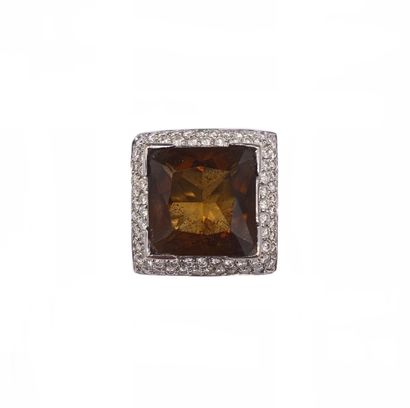 null RING in 18K white gold. The square bezel presents a smoky quartz in a pavé of...