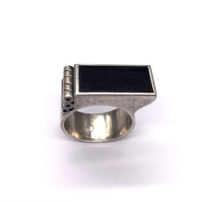 null 
JEAN DESPRES RING in silver holding an onyx rectangle with three cylinders....