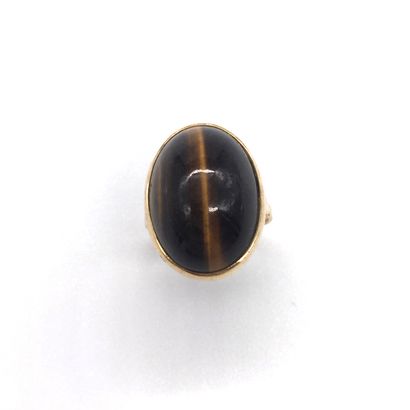 null RING with a tiger's eye cabochon. 18K yellow gold setting presenting a basket...