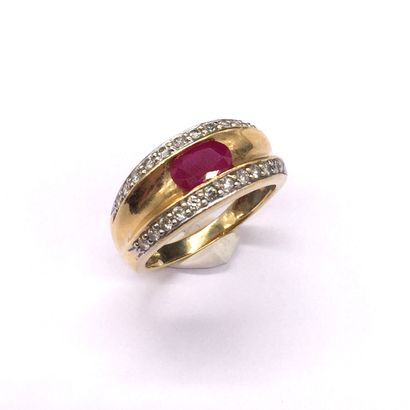 RING holding an oval ruby surrounded by two...