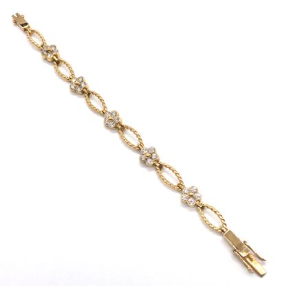 null BRACELET in 18K yellow gold holding a succession of flower motifs composed of...