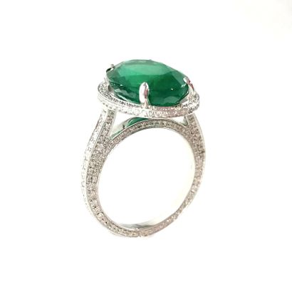 null IMPORTANT RING holding a 6.40 carat oval emerald in a brilliant-cut diamond...