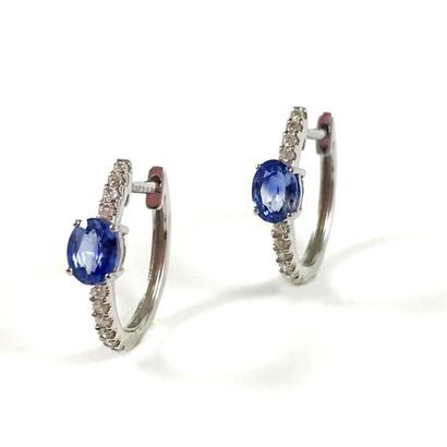 null PAIR OF CRYSTALS set with an oval sapphire on a line of brilliant cut diamonds....