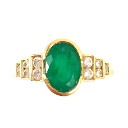null RING set with an oval emerald of about 1.10 carat, surrounded by brilliant-cut...