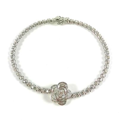 null LINE BRACELET presenting a stylized camellia on a line of brilliant cut diamonds....