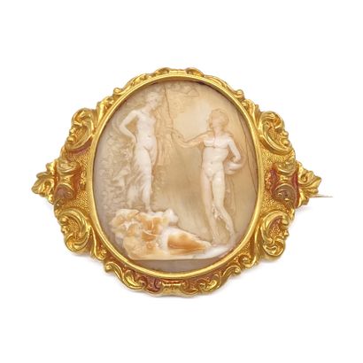  A cameo of two figures in an antique scene. Mounted in 18K yellow gold and decorated...