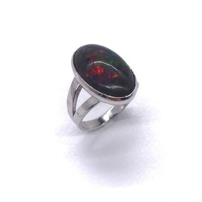  RING set with a black cabochon opal of about 8 carats. Mounted in 18K white gold....