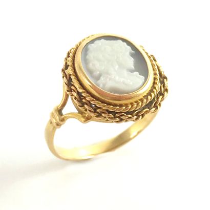 null RING with a cameo showing a woman in profile. Twisted chain setting in 18K yellow...