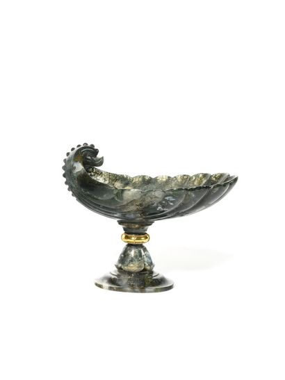 null CUP IN GREEN JASPE, the bowl decorated with a stylized dolphin head. It rests...