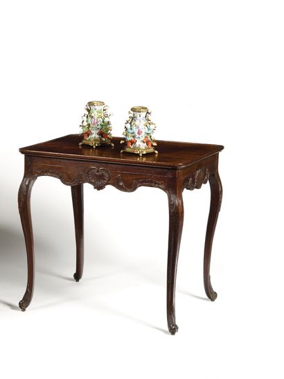 null 
A moulded and carved mahogany table, the top slightly cupped, decorated with...
