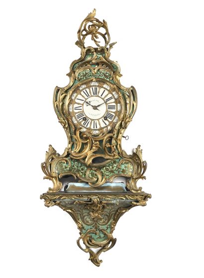 null A brass inlaid clock with a green horn background, the dial with enamelled cartouches...