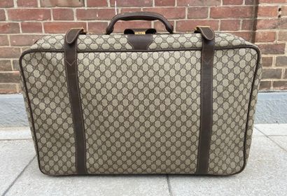  GUCCI 
Suitcase in coated canvas monogrammed and brown leather. 
50 x 70 cm 
(w...