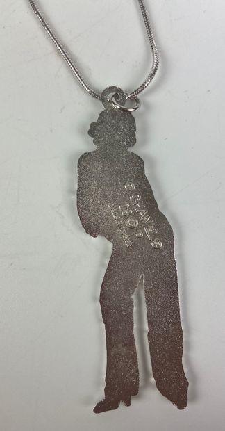  CHANEL 
Sautoir avec un pendentif représentant un mannequin portant une veste au...