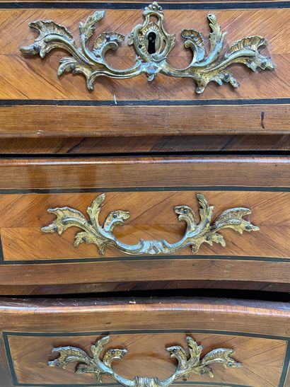 null A veneer and marquetry chest of drawers opening with four drawers on three rows...