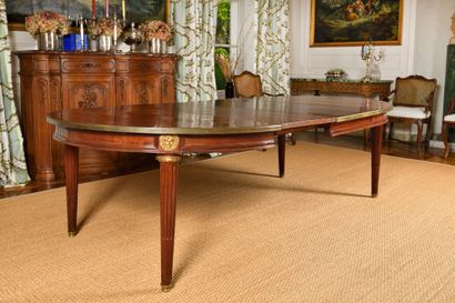 A mahogany oval dining room table with a...