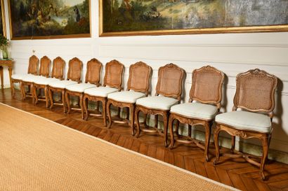  A SET OF TEN MOVED BACK CHAIRS, in natural wood moulded and carved with flowers,...