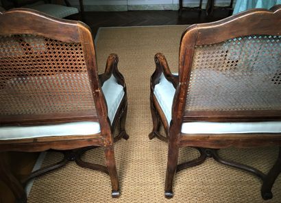  A PAIR OF ARMCHAIRS with an agitated back, in natural wood moulded and carved with...