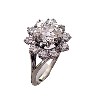 null RING with a floral design holding in its center a 2.89 carats old cut diamond...