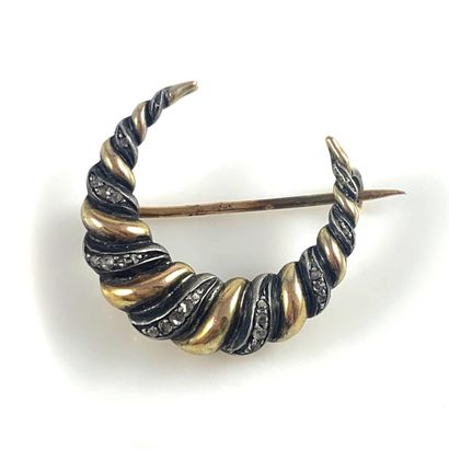 null A crescent moon brooch with rose-cut diamonds and gadroons. Silver and 18K yellow...